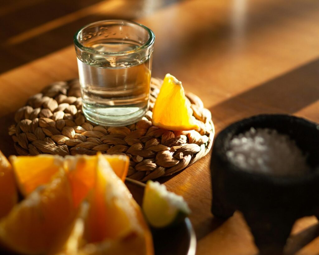 A shot of mezcal with an orange slice and sal de gusano, a classic pairing found in Mexico City’s vibrant mezcalerías.