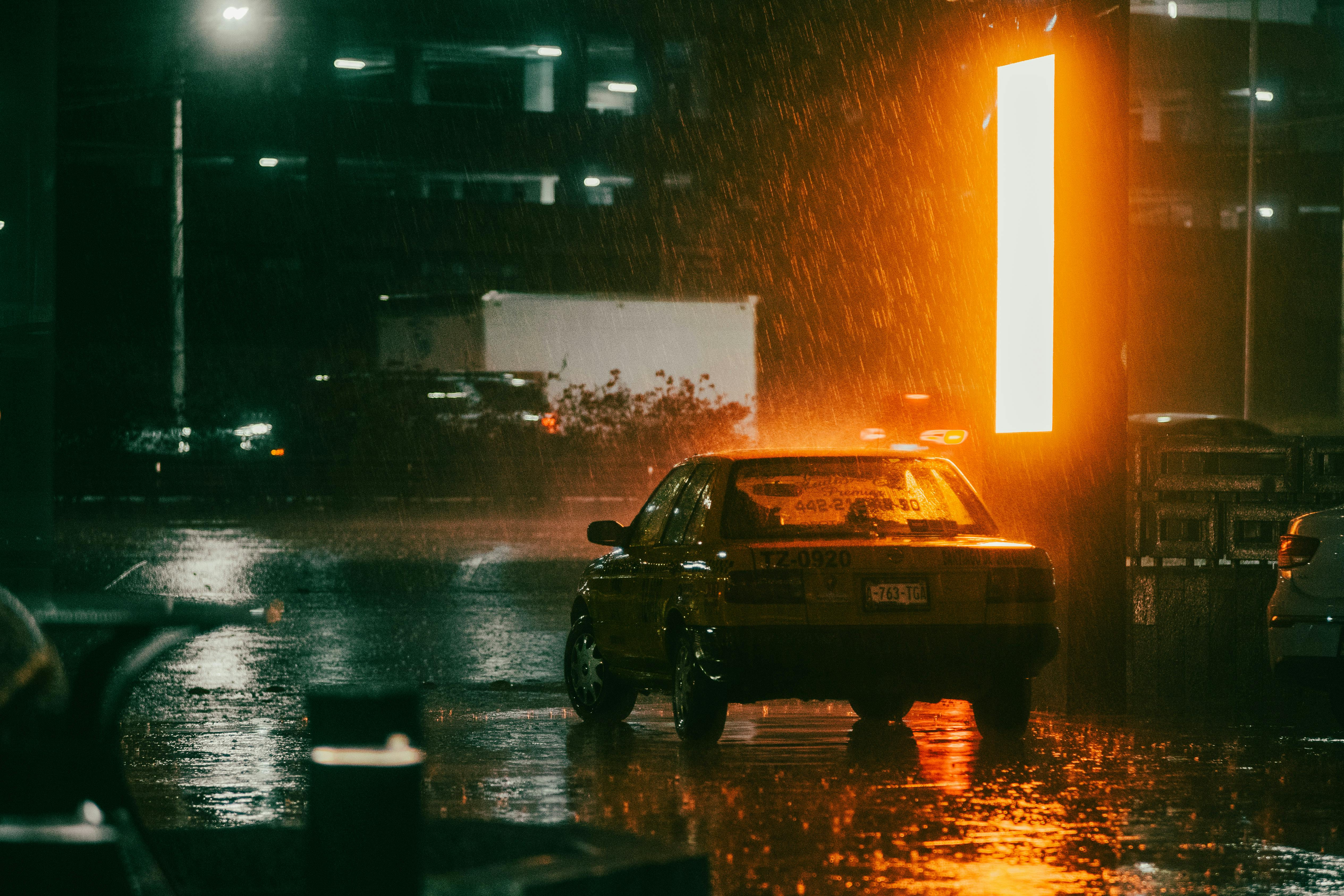 Rainy street in Mexico City with a lone car driving through wet pavement — capturing the tense, isolating atmosphere of Paradais, a visceral novel featured in books and films about Mexico City