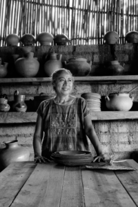 Black and white photo of a woman in a rustic Mexico City kitchen.