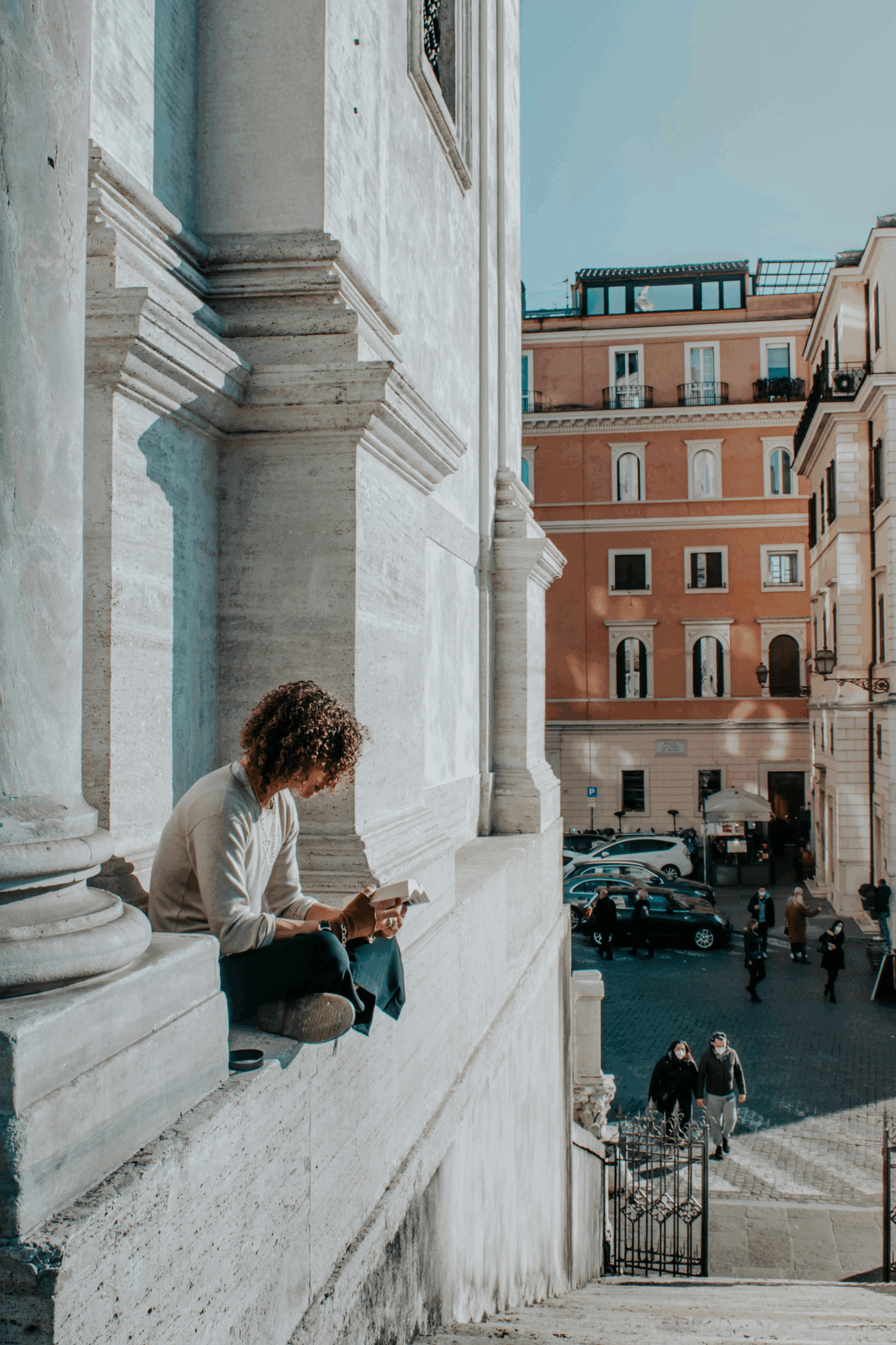 Woman reading in Florence, seated in a white marble alcove — a timeless scene that reflects the stories in books and films set in Tuscany.