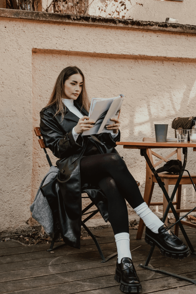 Woman reading the best books set in Tuscany in an outdoor Tuscan cafe