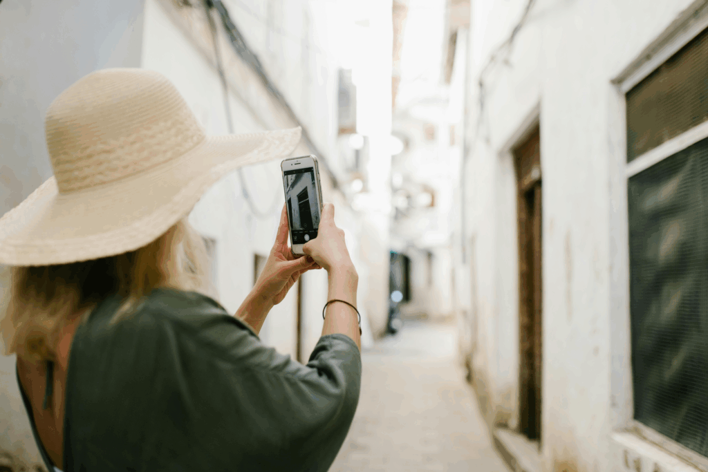 Woman photographing historic architecture on a Florence street, capturing memories during Tuscany region tours.