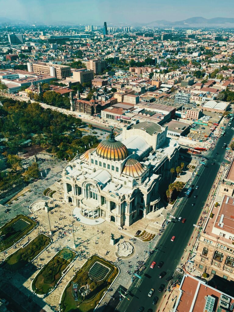 Aerial view of the Palacio de Bellas Artes at golden hour, captured during a private sunset helicopter tour over Mexico City