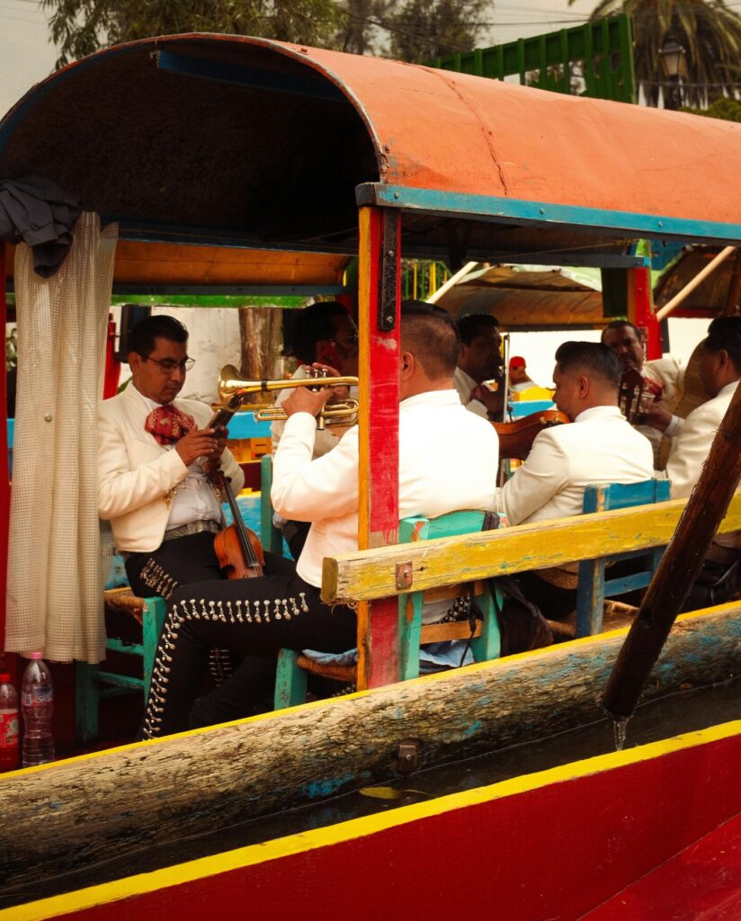 Mariachi musicians performing on a trajinera during a personalized sunrise cruise through Xochimilco’s canals — a colorful cultural experience in Mexico City