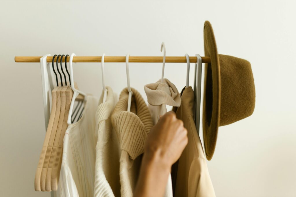 Neutral-toned tops hanging neatly on a rack — a capsule wardrobe foundation.